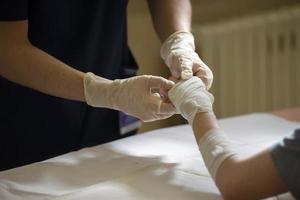 el médico corbatas el del paciente mano con un médico vendaje. foto