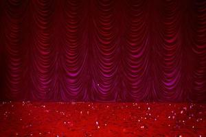 Theatrical background. Red stage curtains and sequined floor. photo