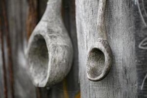 Wooden homemade spoons hang on the wall. photo