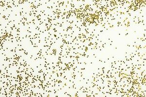 Festive or glamorous background. Gold sparkles scattered on a white background. photo