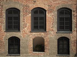 Brick wall of an old building with arched windows. photo