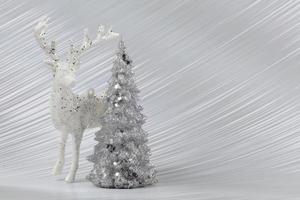 Christmas or New Year background with silver snowy fir tree and deer. Bright festive background. photo