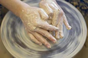 Potter's hands at work. Close-up of a potter's hands with a product on a potter's wheel. Working with clay. photo