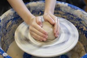 Potter's hands at work. Close-up of a potter's hands with a product on a potter's wheel. Working with clay. photo