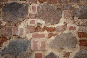 Background of an old wall made of stone and rough brick. photo