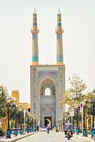 Yazd, Iran, 2022 - Blue Hazireh Mosque during day in Yazd, Iran. Street scene in hot day with pedestrians and traffic photo