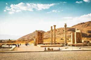 persépolis, irán, 2022 - grupo de turista caminar por gigante columna estatuas histórico persa ciudad Persépolis en Persia foto