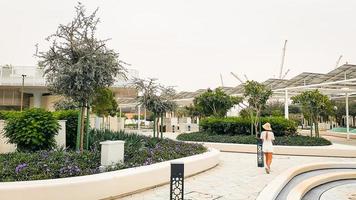 eau, abu dhabi , 2023 - turista visitar caminar en Masdar ciudad central parque . mundos más sostenible comunidades parque infraestructura. urbano bajo en carbon desarrollo proyecto foto