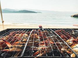 Side view fresh crabs cooked on bbq grill using coil with beach panorama in Oman. Gurman dish preparation photo