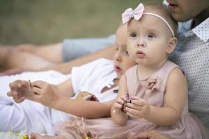 pequeño niña de uno año en el antecedentes de el familia. foto