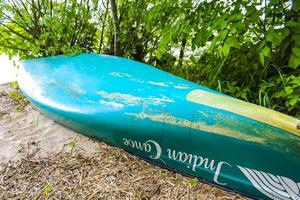 Harrier Sand Lower Saxony Germany 2010 Turquoise green canoe lies on bush on the beach Germany. photo