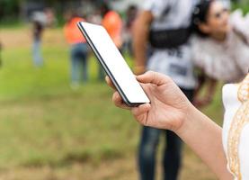 Close up of woman hand using mobile smartphone with blank screen outdoors photo