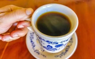 Blue white cup pot with black coffee wooden table Mexico. photo