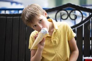 A small child is eating ice cream. Happy boy with a big portion of ice cream. photo