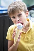 Happy little toddler boy eating colorful ice cream in summer, outdoors photo