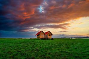 Landscape image of Abandoned twin house near Chalerm Phra Kiat road at sunset in Thale Noi, Phatthalung, Thailand photo