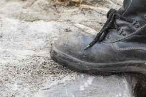 bota de cuero trekking en la roca foto