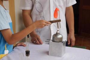 de cerca estudiante es haciendo Ciencias experimentar acerca de reacción de aire en globo desde hirviendo agua en prueba tubo en linterna. concepto, Ciencias actividad, educación lección. aprendizaje por haciendo, observar y prueba. foto