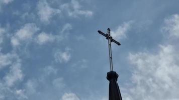 de kruis is geplaatst Aan de koepel van de Katholiek tempel, de kerk, tegen de achtergrond van drijvend wit wolken. de onderwerp is geloof. video