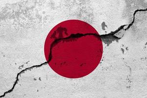 Earthquakes in Japan, flag Japan on a wall with cracks from an earthquake photo