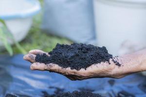 Hands holding abundance soil for agriculture or preparing to plant  Testing soil samples on hands with soil ground background. Dirt quality and farming concept. Selective focus on black soil in front photo