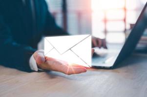 Email concept, businessman using computer laptop on table in office blurred background photo