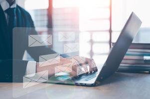 Email concept, businessman using computer laptop on table in office blurred background photo