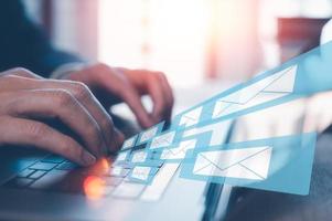 Email concept, businessman using computer laptop on table in office blurred background photo