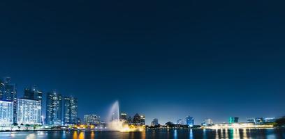 Night view of skyscrapers with river in business district of the capital city in Bangkok, Thailand. with copy space and text design for business photo