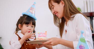 Mother gave her lovely daughter a birthday cake. photo