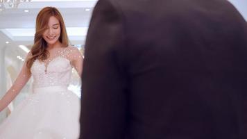 Young Asian couple trying on wedding dresses in wedding studio. photo