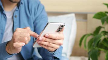 A man using a smartphone presses with his finger, reads social networks on the Internet, typing text or shopping online photo
