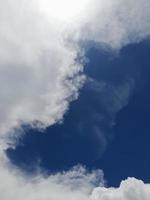 Beautiful white clouds on deep blue sky background. Large bright soft fluffy clouds are cover the entire blue sky. photo