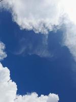 Beautiful white clouds on deep blue sky background. Large bright soft fluffy clouds are cover the entire blue sky. photo