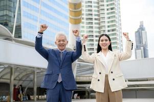 Portrait of Asian senior mature middle aged businessman and young businesswoman in modern city photo