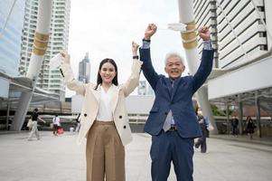 Asian senior mature middle aged businessman and young businesswoman taking mask off in modern city photo