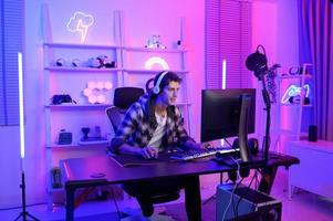 Young Caucasian man Pro Gamer have live streaming  and chatting  with his  fans at home photo