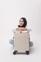 A young muslim woman tourist with baggage  on white background photo