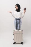 A young muslim woman tourist with baggage  on white background photo