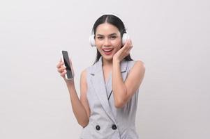 A young woman wearing headphones enjoying with music on white background photo