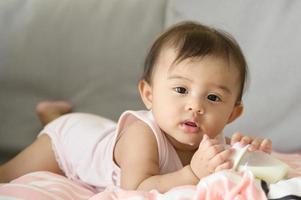 A baby girl is drinking milk bottle, family, child, childhood and parenthood concept photo