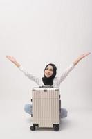 A young muslim woman tourist with baggage  on white background photo