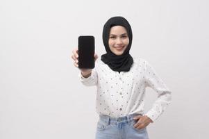 Beautiful musllim woman with hijab using smartphone over white background, technology concept. photo