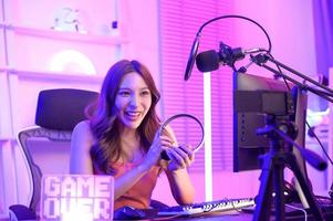 Young Asian Pretty woman Pro Gamer have live streaming , singing  and chatting  with her fans  at home photo