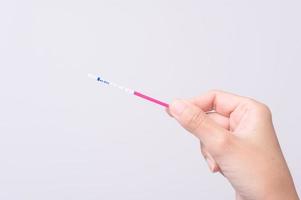 Close up woman using Ovalation LH test  or HCG Pregnancy test on white background photo