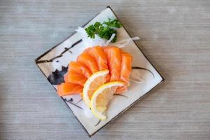 salmón sashimi en japonés estilo Fresco servir en blanco lámina. foto