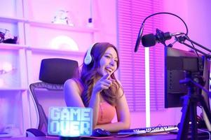 Young Asian Pretty woman Pro Gamer have live streaming , singing  and chatting  with her fans  at home photo