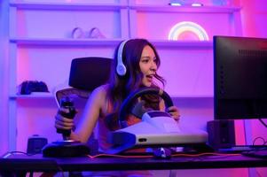joven asiático bonito mujer Pro jugador tener En Vivo transmisión jugando vídeo juego, carreras juego a hogar foto