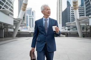 Portrait of Asian senior mature middle aged businessman in modern city photo