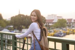 Portrait of young beautiful woman with an electric scooter  over bridge in modern city  background photo